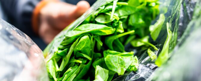 Closeup Of Person Hands Holding Fresh Raw, Plastic Packaged Bag Of Green Spinach, Vibrant Color, Healthy Salad