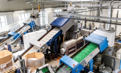 Blick in die Verwertungs- und Produktshalle der LH Plastics GMBH. Man sieht drei Maschinen zur Herstellung von Regranulat in einer hohen Halle.
