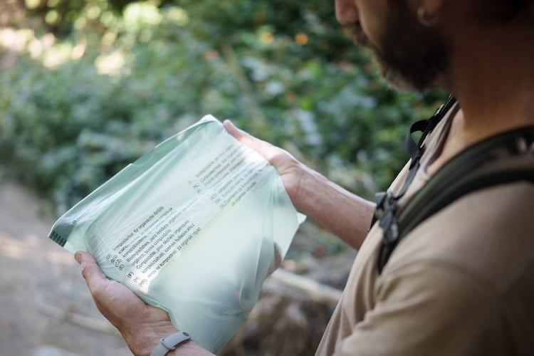 Mann hält Bioplastik Müllbeutel in den Händen.
