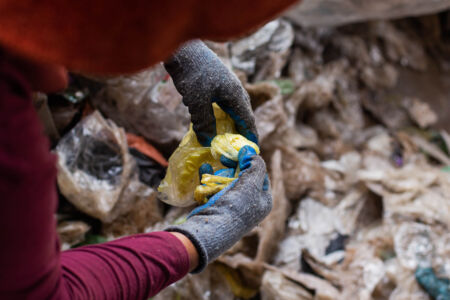 Wildes Plastik wird aus einem Haufen Müll aussortiert.