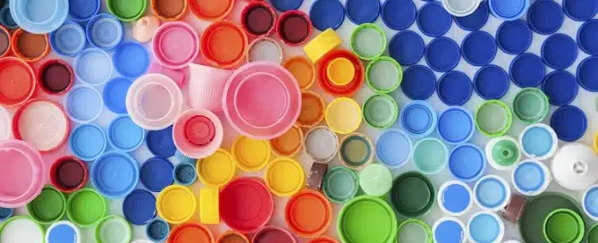 Nahaufnahme von bunten Flaschenverschlüssen, die aus recyceltem Kunststoff hergestellt wurden – ein Symbol für nachhaltige Verpackung.