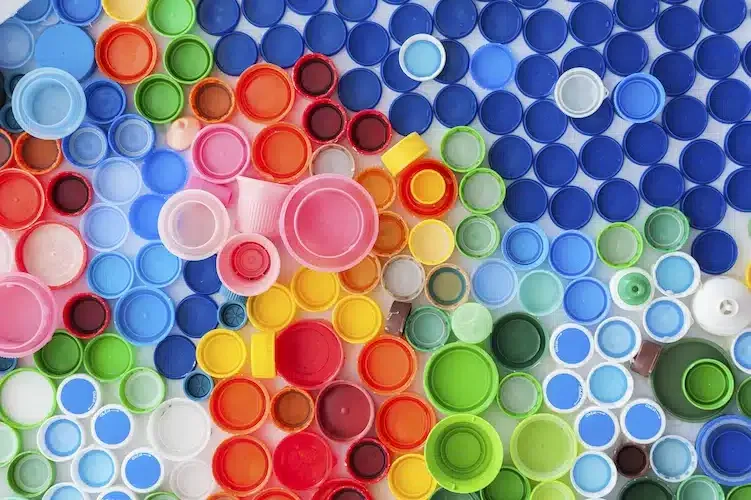 Nahaufnahme von bunten Flaschenverschlüssen, die aus recyceltem Kunststoff hergestellt wurden – ein Symbol für nachhaltige Verpackung.